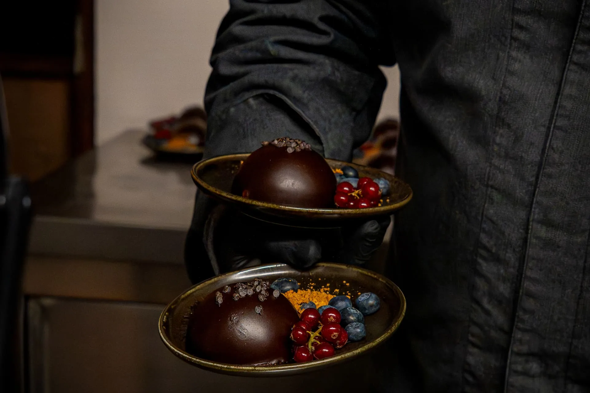 Bediening met twee afgewerkte chocoladedesserts op schalen