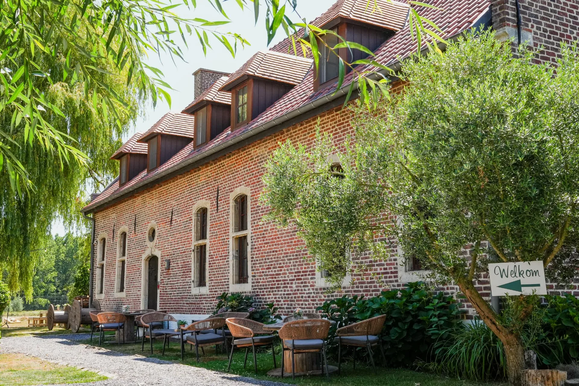 De bakstenen hoeve van Huis van Mem met het terras en de tuin
