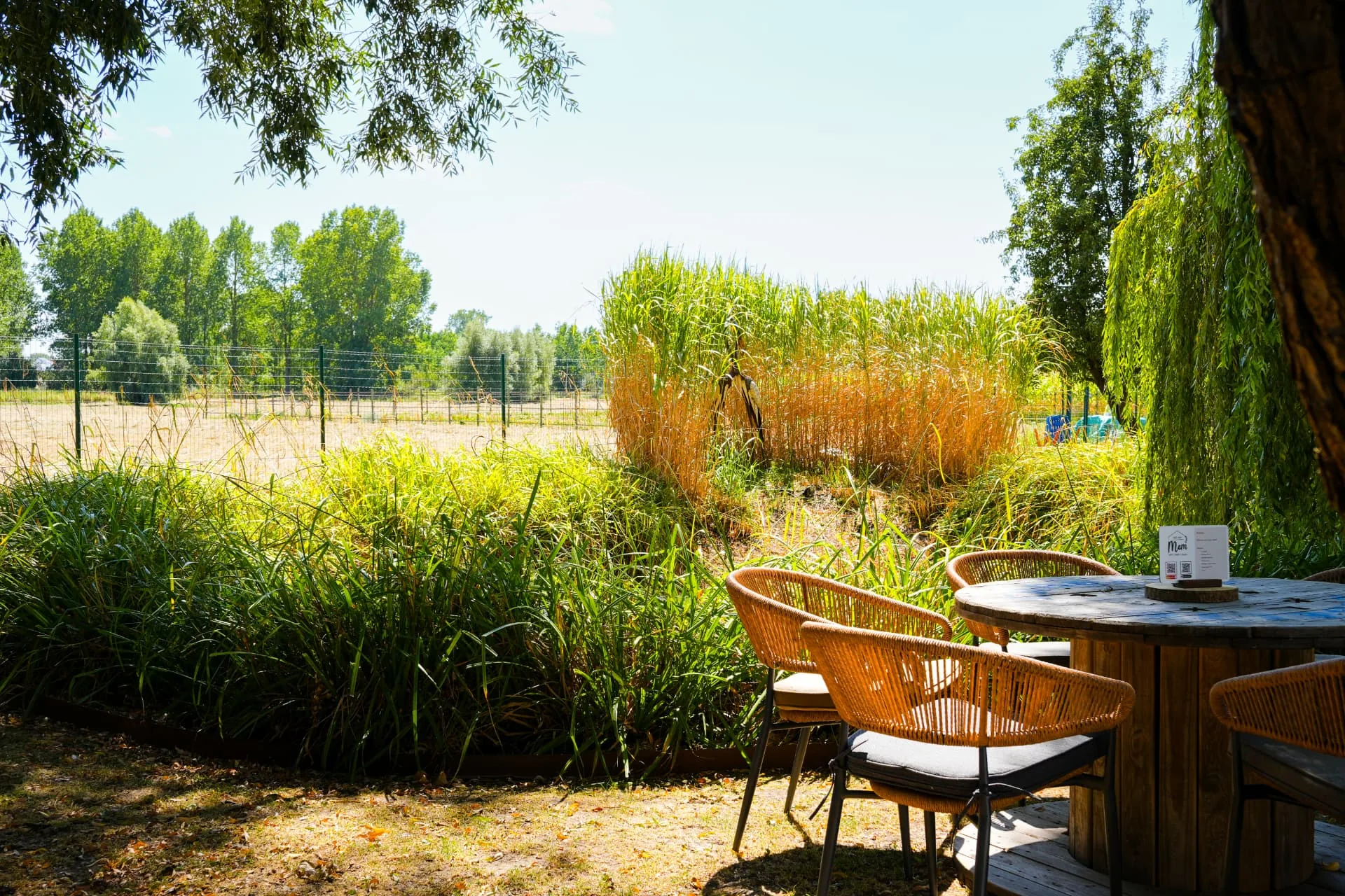 Zithoek met tafel in de groene tuin met uitzicht over het omliggende landschap